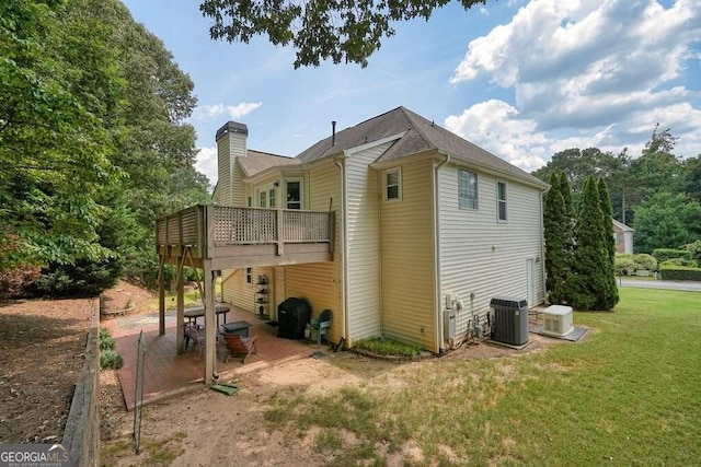 rear view of house with a patio, cooling unit, a deck, and a yard