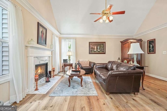 living room featuring light wood-type flooring, lofted ceiling, a fireplace, and crown molding