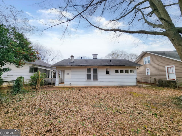 rear view of house featuring a chimney