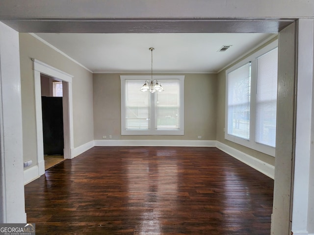 unfurnished dining area with a chandelier, visible vents, crown molding, and wood finished floors