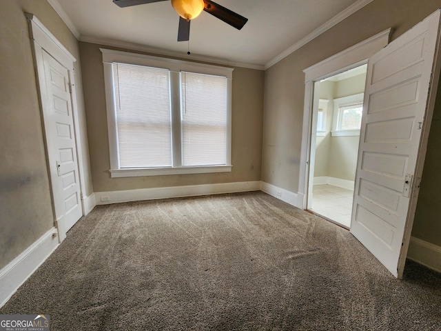 unfurnished bedroom featuring ornamental molding, carpet, a ceiling fan, and baseboards