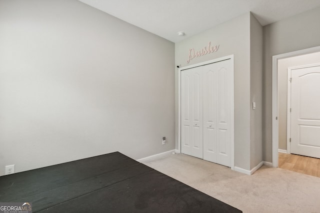 unfurnished bedroom with a closet and light carpet