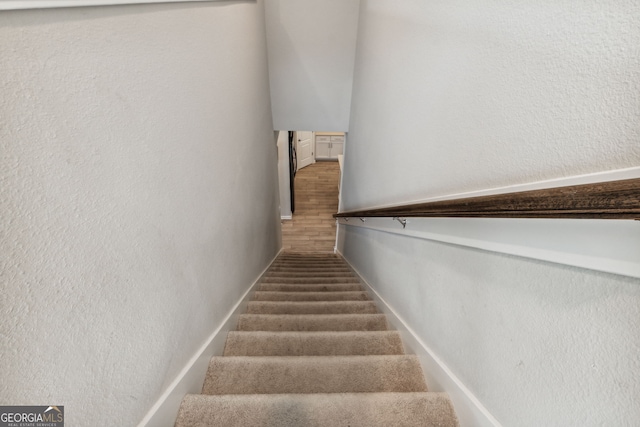 staircase with hardwood / wood-style flooring