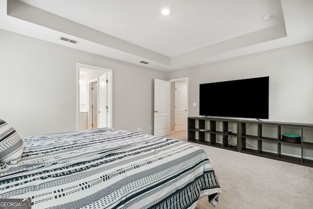 bedroom featuring carpet floors and a tray ceiling