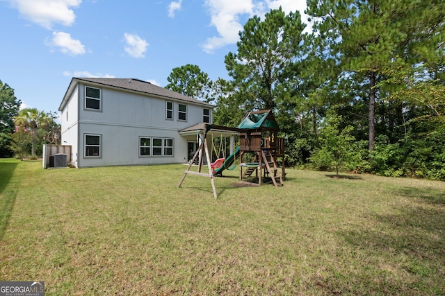 back of property featuring central air condition unit, a yard, and a playground