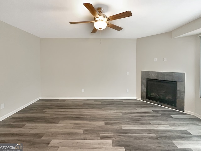 unfurnished living room with ceiling fan, hardwood / wood-style floors, and a tile fireplace