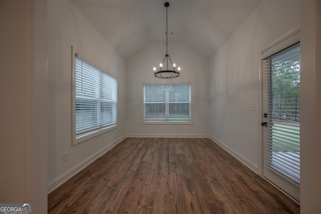 unfurnished dining area featuring vaulted ceiling, dark hardwood / wood-style flooring, and a chandelier