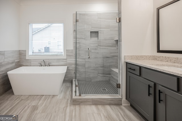 bathroom featuring vanity, separate shower and tub, and tile walls