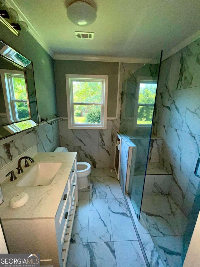 bathroom featuring ornamental molding, vanity, tile patterned flooring, tile walls, and toilet