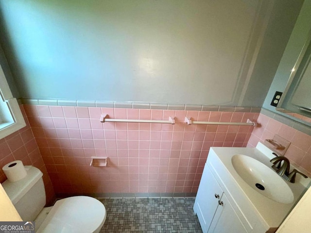 bathroom with tile patterned flooring, tile walls, toilet, and vanity