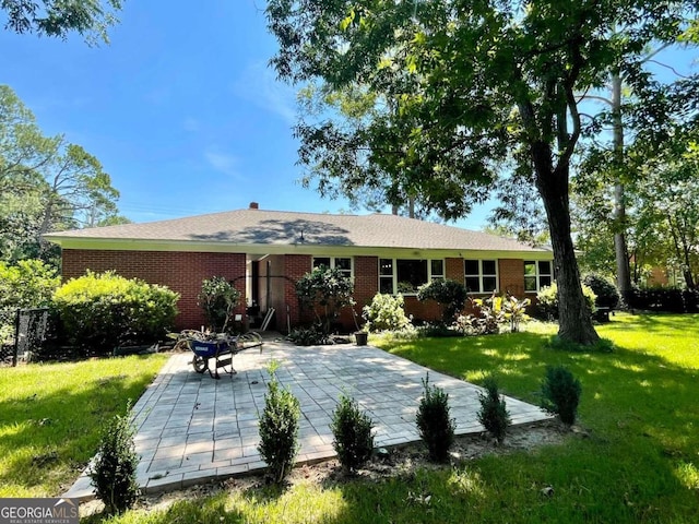 rear view of property with a patio and a yard