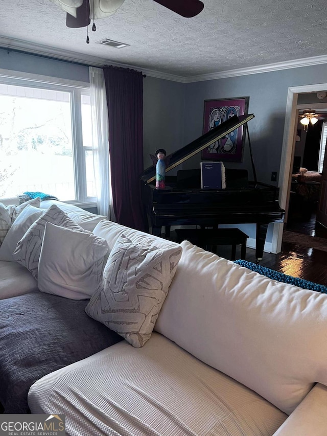 bedroom with ceiling fan, ornamental molding, and a textured ceiling