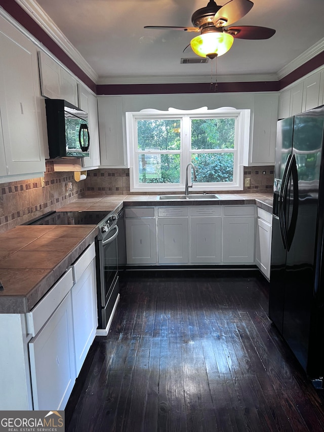 kitchen featuring ceiling fan, dark hardwood / wood-style flooring, tasteful backsplash, white cabinets, and black appliances