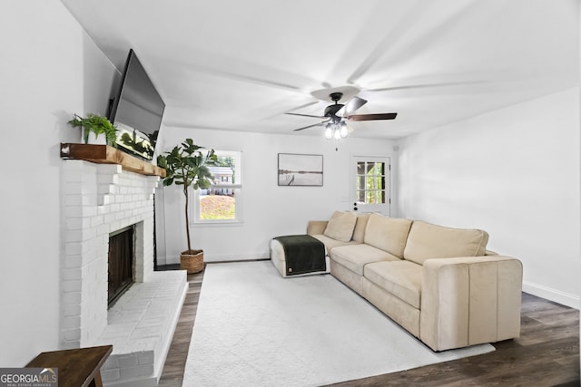 living room with a fireplace, ceiling fan, and wood-type flooring