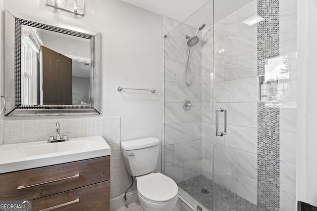 bathroom featuring decorative backsplash, vanity, walk in shower, and toilet