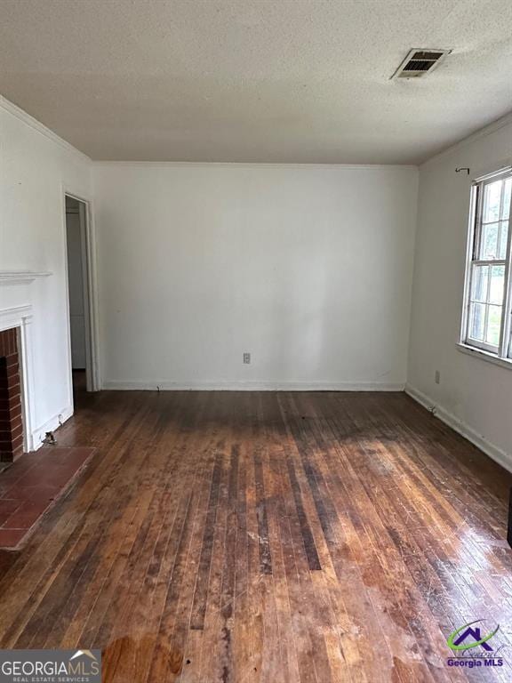 unfurnished living room with hardwood / wood-style flooring and a textured ceiling