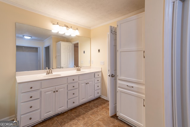 bathroom with ornamental molding, tile patterned floors, vanity, and a textured ceiling