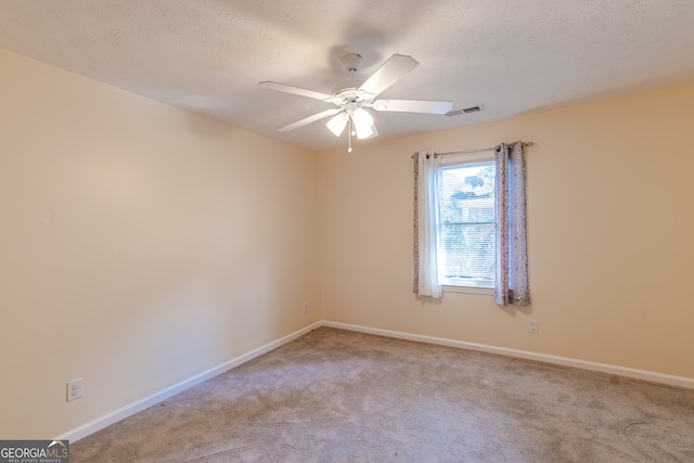 carpeted empty room with a textured ceiling and ceiling fan