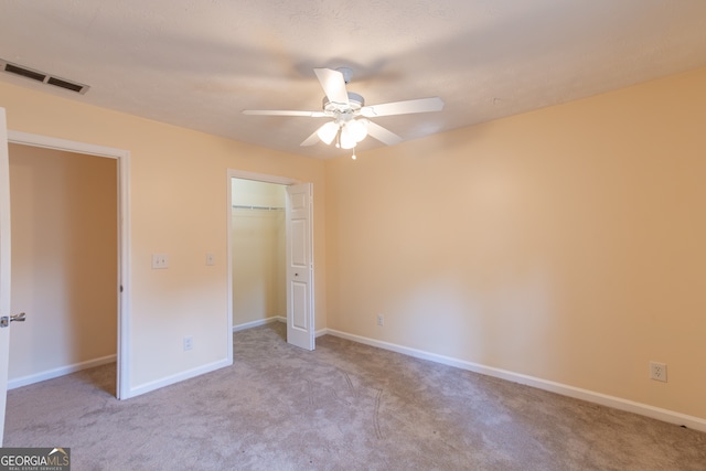 unfurnished bedroom with ceiling fan, a closet, and light colored carpet