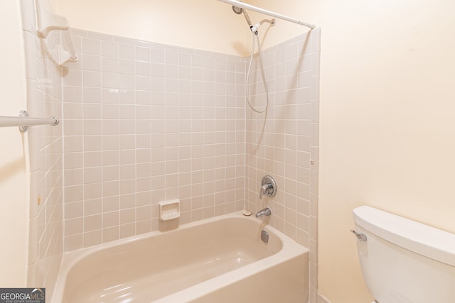 bathroom featuring toilet and tiled shower / bath