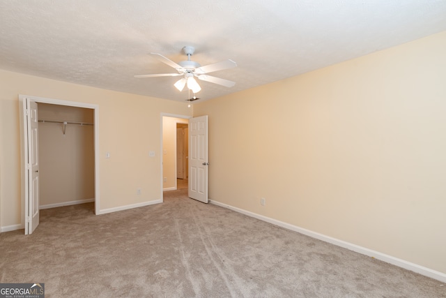 unfurnished bedroom featuring ceiling fan, a closet, and light carpet