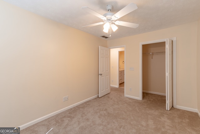 unfurnished bedroom with ceiling fan, a closet, and light colored carpet