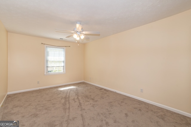 carpeted spare room featuring ceiling fan