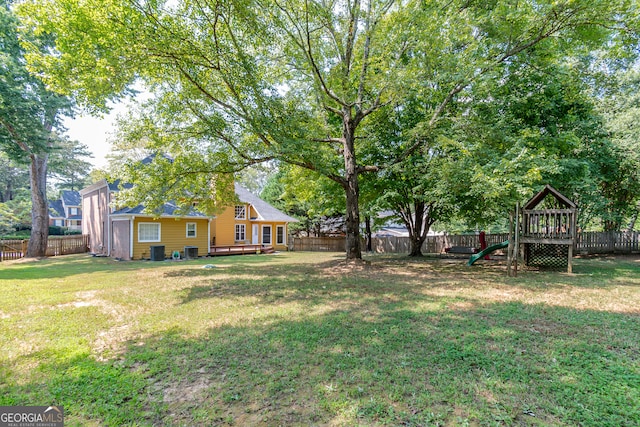 view of yard featuring a playground, central AC, and a wooden deck