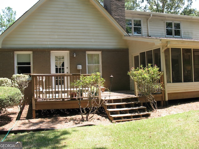 rear view of house featuring a yard and a deck