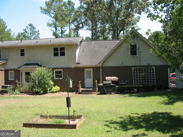 back of property featuring a yard and central AC unit