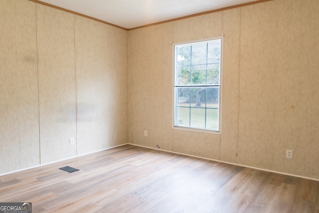 unfurnished room with light wood-type flooring and crown molding