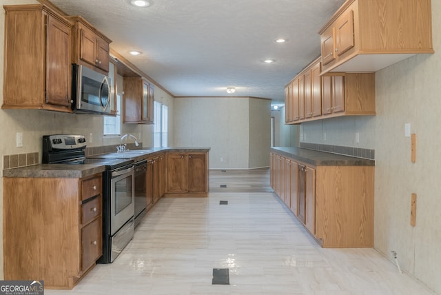 kitchen featuring a textured ceiling, black appliances, and sink