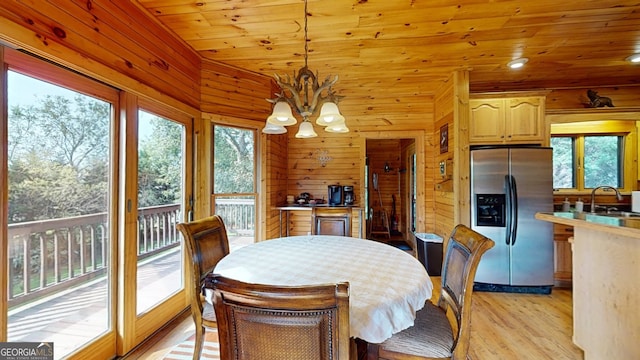 dining area featuring wood walls, light hardwood / wood-style flooring, a chandelier, and wood ceiling