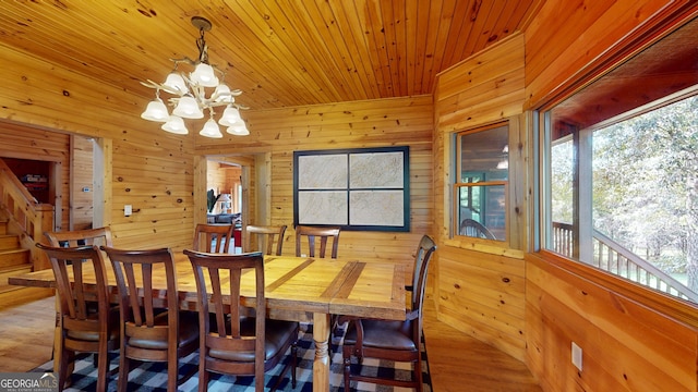 dining space with wooden walls, a notable chandelier, wood ceiling, and wood-type flooring