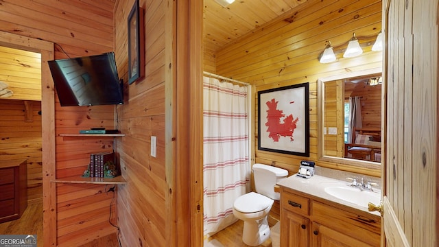 bathroom featuring wood walls, hardwood / wood-style flooring, vanity, wood ceiling, and toilet