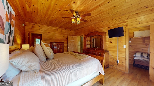 bedroom with wood walls, wood ceiling, light hardwood / wood-style flooring, and ceiling fan