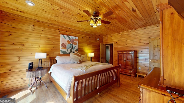 bedroom featuring wooden ceiling, wood-type flooring, ceiling fan, and wood walls