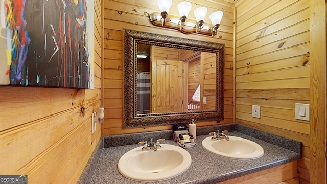 bathroom featuring wood walls and dual bowl vanity