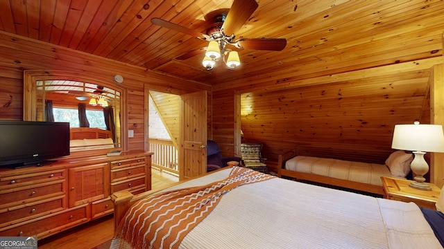 bedroom featuring ceiling fan, wooden walls, light hardwood / wood-style floors, and wooden ceiling