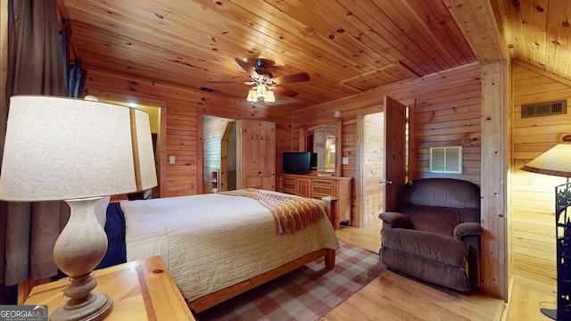 bedroom with wood walls, ceiling fan, light hardwood / wood-style floors, and wooden ceiling