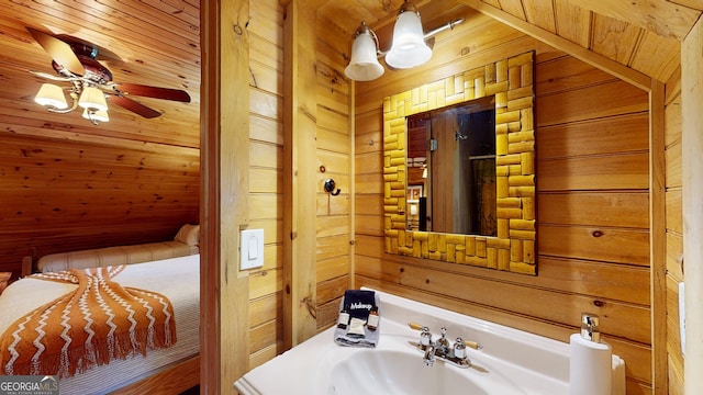 bathroom with wood ceiling, wooden walls, and sink