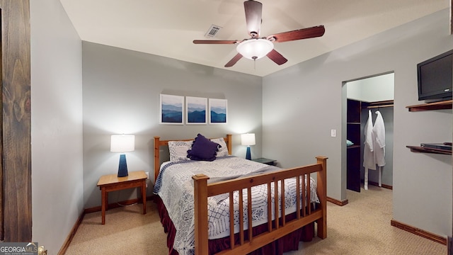 carpeted bedroom with ceiling fan, a closet, and a walk in closet