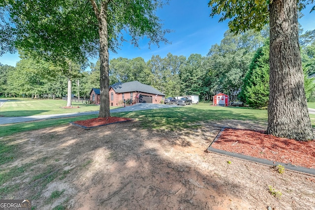 view of yard with a garage, a shed, and an outdoor structure