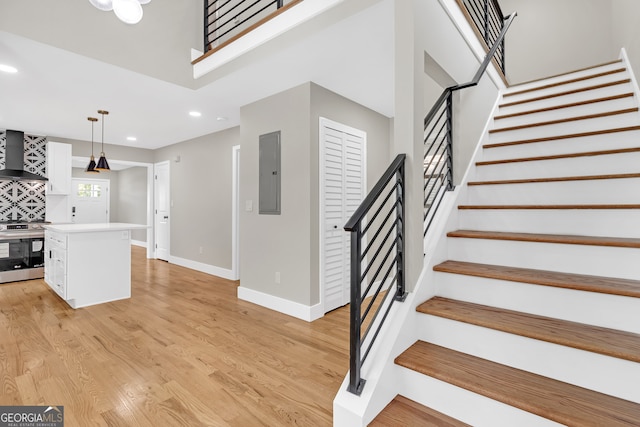 staircase with hardwood / wood-style flooring and electric panel