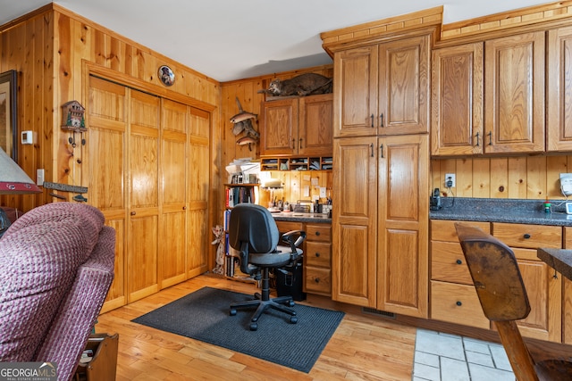 home office featuring wood walls and light wood-type flooring