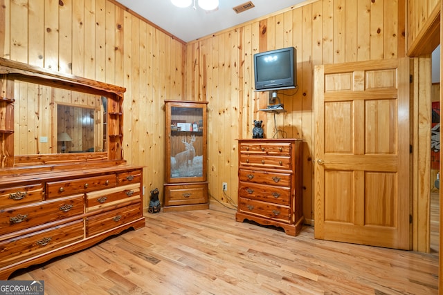 bedroom with light hardwood / wood-style floors and wooden walls