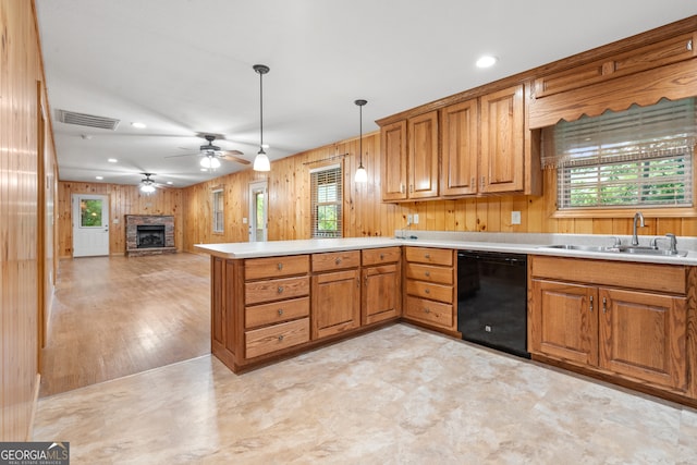 kitchen featuring ceiling fan, hanging light fixtures, dishwasher, sink, and a fireplace