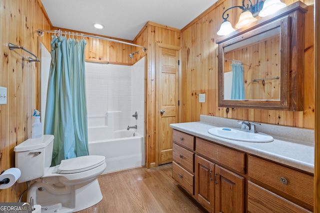 full bathroom with hardwood / wood-style floors, wood walls, shower / tub combo with curtain, vanity, and toilet