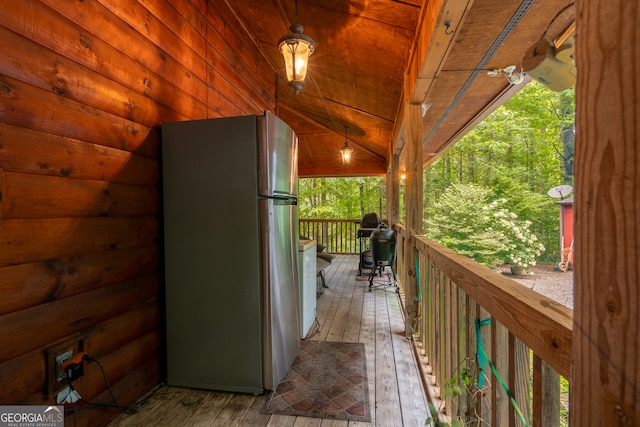 exterior space with stainless steel fridge, lofted ceiling, wooden ceiling, and wood-type flooring