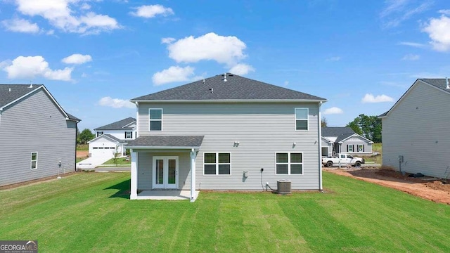 back of house with central air condition unit, french doors, and a yard